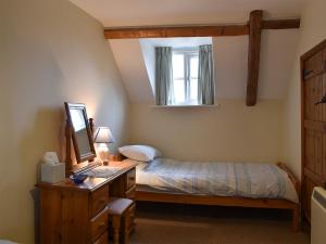 1 dormitorio con 1 cama y escritorio con ordenador en Vista Cottage - Uk13205, en Brancaster