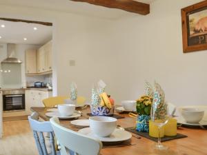 mesa de comedor con platos, tazones y sillas en Bumblebee Nook, en Penrith