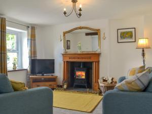 a living room with a fireplace and a mirror at Bumblebee Nook in Penrith