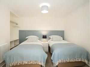 two beds in a small room with blue and white at High Street in Kirkcudbright