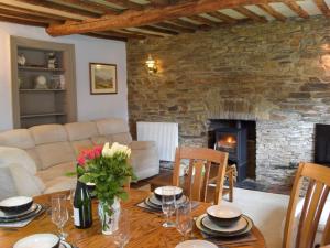 a living room with a table and a fireplace at The Farmhouse - Uk13183 in Cwm-Morgan
