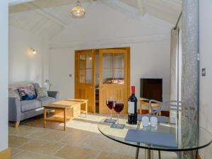 a living room with a glass table and wine glasses at Buttercup Barn - Uk12963 in Royal Wootton Bassett