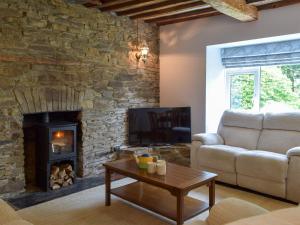 a living room with a couch and a fireplace at The Farmhouse - Uk13183 in Cwm-Morgan