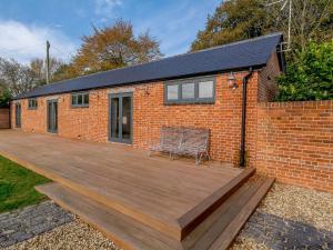 a brick house with a wooden deck in front of it at Buttercup Barn - Uk12963 in Royal Wootton Bassett
