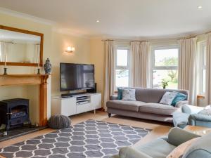 a living room with a couch and a television at Saffron in Portpatrick