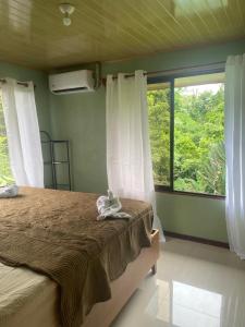 a bedroom with a bed and a large window at La Reina del Mar in Drake