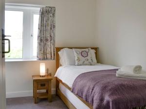 a small bedroom with a bed and a window at Ivy Cottage in Grassington