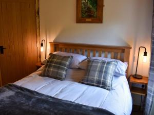 een bed met twee kussens in een kamer bij Gelderslack Barn in Nateby
