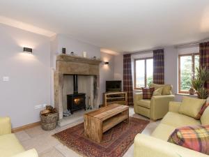 a living room with a fireplace and a couch at Sands Farm Cottage in Luddenden Foot