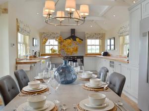 a dining room with a table with chairs and a vase at Farrington House in Lowthorpe