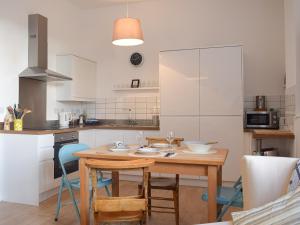 cocina con mesa de madera y sillas en Apartment 6 harlech en Criccieth