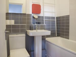克里基厄斯的住宿－Apartment 6 harlech，浴室配有盥洗盆、卫生间和浴缸。