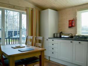 a kitchen with a wooden table and a table and chairs at Bransty in Keswick
