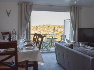 ein Wohnzimmer mit einem Sofa, einem Tisch und einem TV in der Unterkunft What A View! in Whitby