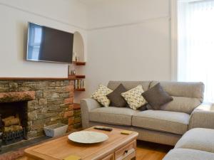 a living room with a couch and a fireplace at The Beeches in Bassenthwaite