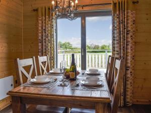 comedor con mesa de madera y ventana grande en Birch Lodge - Uk30006 en Lindal in Furness