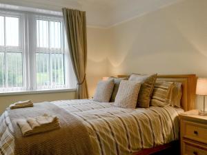 a bedroom with a bed with pillows and a window at The Beeches in Bassenthwaite