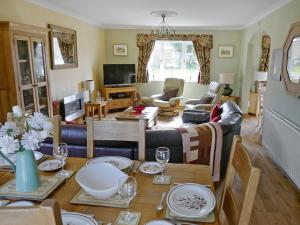 a living room with a table and a couch at Kingfisher Cottage in Amble
