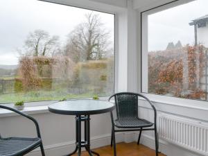 a table and two chairs in a room with a window at The Beeches in Bassenthwaite