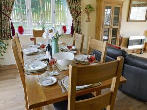 a dining room table with plates and glasses of wine at Kingfisher Cottage in Amble