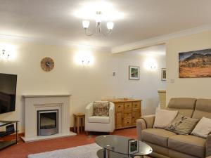 sala de estar con sofá y chimenea en Hoot House, en Abergynolwyn