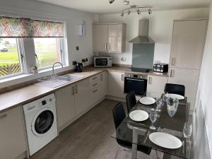 a kitchen with a table and a sink and a dishwasher at Ritson Wharf in Maryport