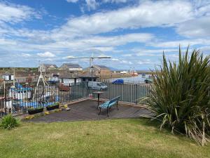 a bench sitting on a deck near the water at Ritson Wharf in Maryport