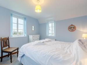 a bedroom with a large white bed and a chair at The Old Vicarage in Stowe