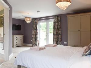 um quarto com uma grande cama branca e uma janela em The Cottage At Stainsacre Hall em Hawsker