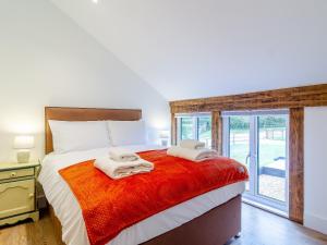 a bedroom with a large bed with towels on it at Skylark Barn-uk31354 in Swaffham