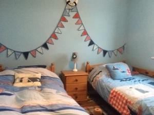 a bedroom with two beds and flags on the wall at Tyn Y Mur in Morfa Nefyn