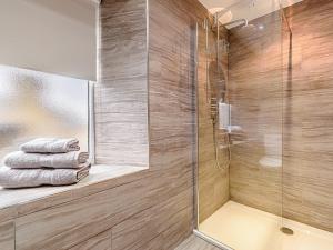 a bathroom with a shower with a glass door at Shawdon Hill Coach House in Whitby