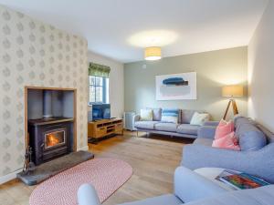 a living room with a couch and a fireplace at Cliff Cottage in Kalnakill