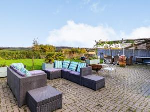 a patio with couches and a table and a grill at The Cider Barn in Buckland St Mary