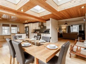 a dining room and living room with a wooden table and chairs at Mill View in Aberfeldy