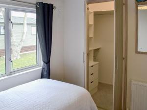 ein Schlafzimmer mit einem Bett und einem großen Fenster in der Unterkunft Ocean Glade - Uk32963 in Corton