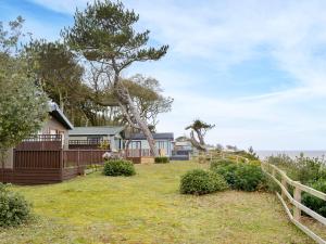 ein Haus mit einem Baum und einem Zaun in der Unterkunft Ocean Glade - Uk32963 in Corton