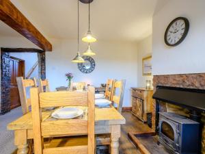 a dining room with a table and a fireplace at Curlew Cottage in Mawbray