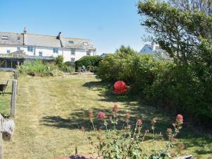 a yard with a red ball in the grass at Curlew Cottage in Mawbray
