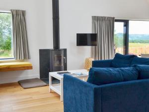 a living room with a blue couch and a fireplace at Barrach in Ardfern