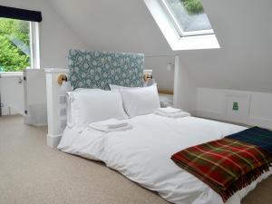 a white bed in a room with a window at Barrach in Ardfern