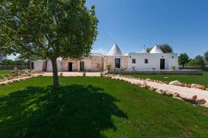a tree in the grass in front of a building at Trullo Coco' by BarbarHouse in Ostuni
