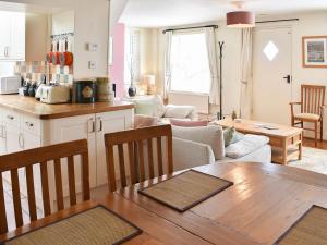 cocina y sala de estar con mesa de madera y cocina y sala de estar. en Seaport Cottage en Ventnor