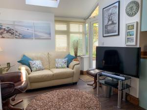 a living room with a couch and a flat screen tv at The Boathouse Uk33900 in Waldringfield