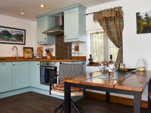 a kitchen with blue cabinets and a wooden table at The Boathouse Uk33900 in Waldringfield