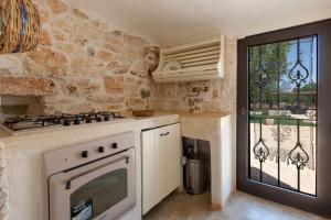 a kitchen with a stove top oven next to a window at Trullo Coco' by BarbarHouse in Ostuni