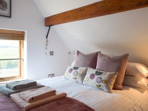 a bedroom with a bed with pillows and a window at Twin Oaks in Crudgington