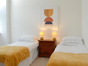 een slaapkamer met 2 bedden en een nachtkastje met 2 kaarsen bij Helena in Prestwick