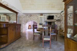 a dining room with a table and a fireplace at Trullo Coco' by BarbarHouse in Ostuni