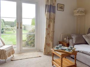 a living room with a couch and a glass door at Cheviot View in Beal